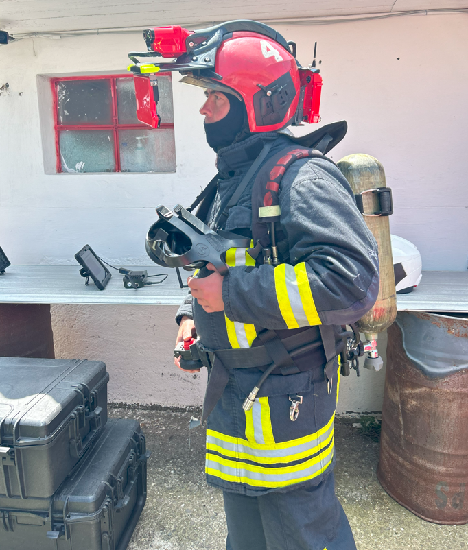 A romanian firefighter ready for a fire test with the iFalconHM system mounted on the helmet